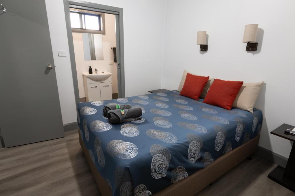 a bedroom with a bed with a blue comforter at Broken Hill Tourist Lodge in Broken Hill