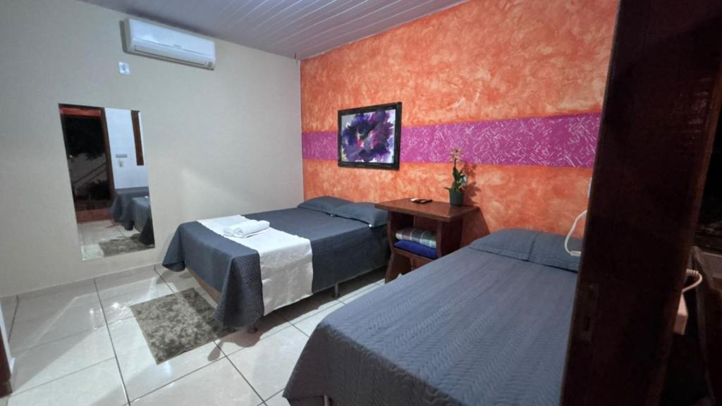 a hotel room with two beds and a mirror at Pousada Moaçara in Estivado