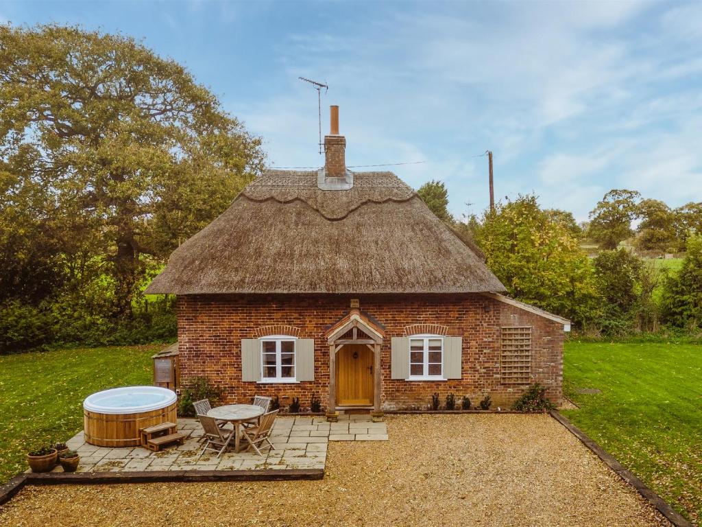 a small brick house with a grass roof at New Lane Cottage in Worstead