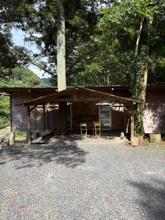 a building with two chairs and a table and a tree at YAMAYA BASE 2 in Miyoshi