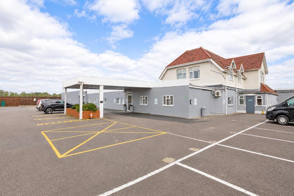 a large white building with a parking lot at Citi Hotel London Heathrow in Hillingdon