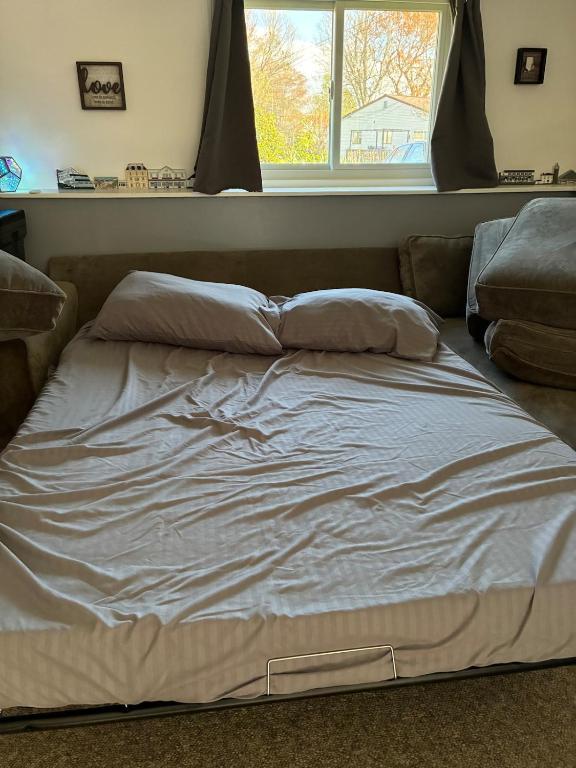 an unmade bed in a bedroom with a window at Ocean Town Homestay in Westerly
