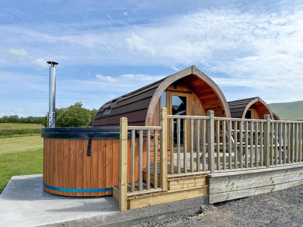 a large wooden building with a fence around it at Manx View-Uk1396 in Corney