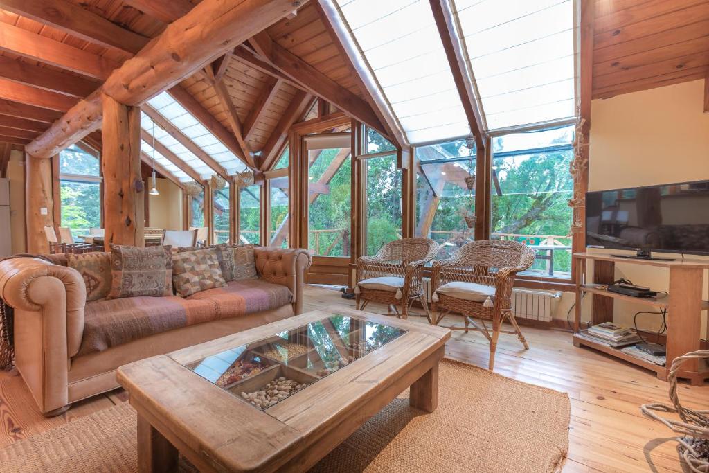 Una sala de estar con un sofá y un televisor. en BOG Casa Ciprés, en Villa La Angostura