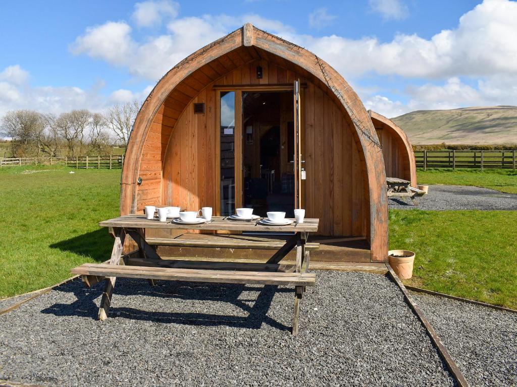 a wooden tent with a table in front of it at Barn Scar-Uk1394 in Corney