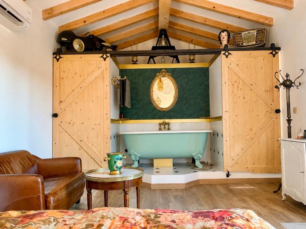 a bathroom with a tub in a room with wooden walls at Ô Dentelles in Vacqueyras