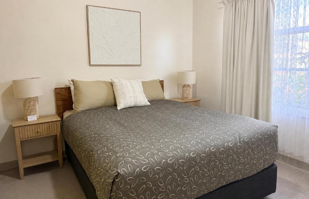 a bedroom with a bed and two night stands with lamps at Kimba Units - Better than a motel room - self contained and pet friendly in Kimba