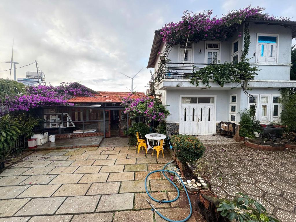 a house with a garden hose in front of it at Mây inn' Cầu Đất - Homestay in Xuân Trường