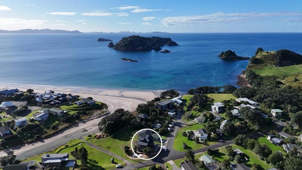 an aerial view of a beach with houses and the ocean at Serenity Sands Beach House in Hahei