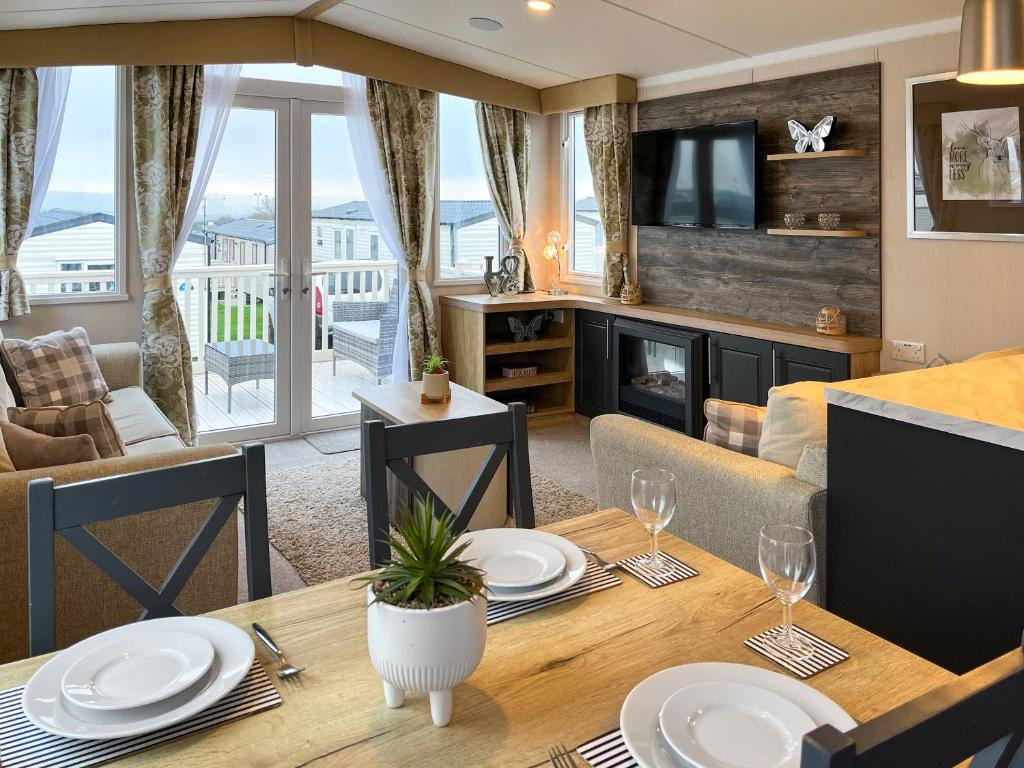 ein Esszimmer mit einem Tisch und ein Wohnzimmer in der Unterkunft Maple 8 in Filey