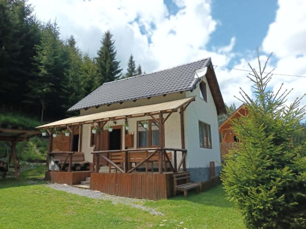 a small white house with a roof at Csillag kulcsoshaz in Gheorgheni