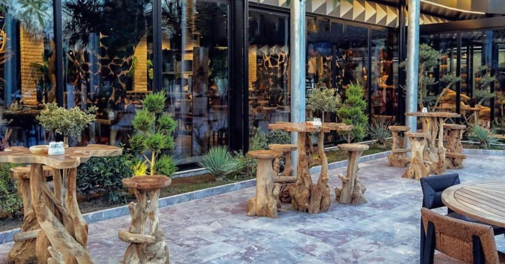 a group of wooden tables in front of a store at Shkodër Grand Hotel Europa, Affiliated by Meliá in Shkodër