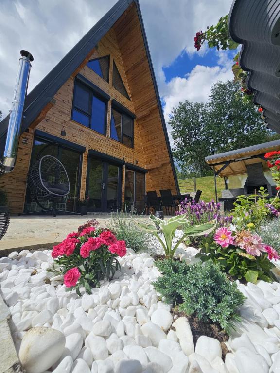 a house with a garden of flowers in front of it at Hill House Doftana in Seciuri