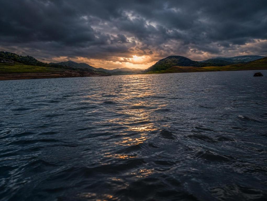 a large body of water with a cloudy sky at Elee Villa - Waterfront Retreat with Victoria Reservoir & Mountain Views in Teldeniya