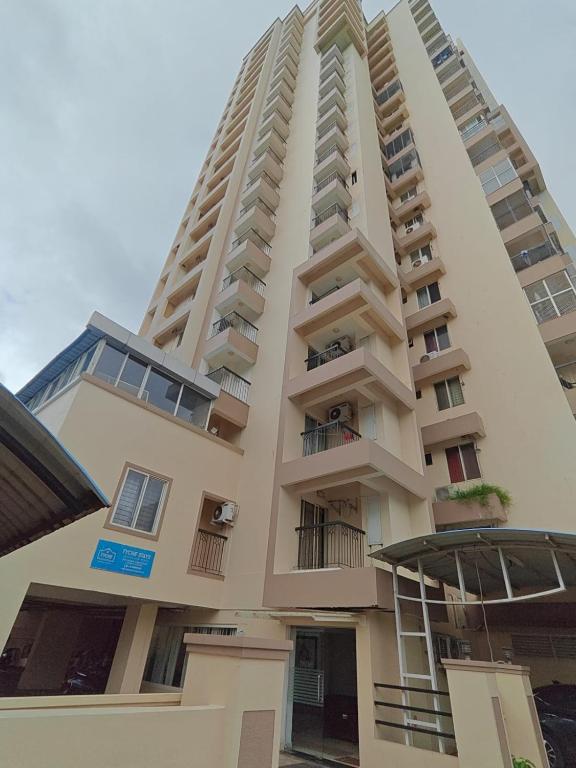 a tall white building with balconies on it at Tyche Stays in Trivandrum
