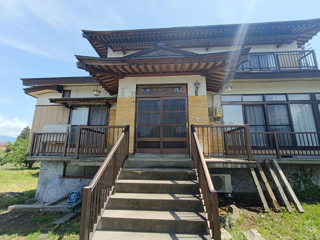 ein Haus mit Treppe, die zur Haustür führt in der Unterkunft Otowa音和 in Kijimadaira