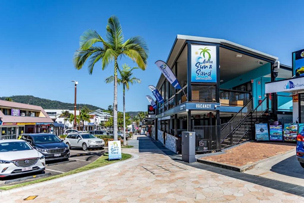 a street with cars parked in a parking lot at Airlie Sun & Sand Accommodation #5 KIDS STAY FREE in Airlie Beach