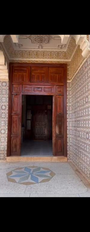 a room with a large wooden door with a tile floor at Villa ben lahbib II in Khenifra