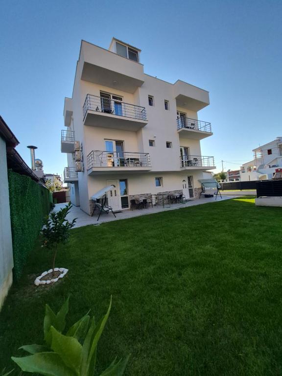 a large white building with a lawn in front of it at Silitur Keramoti in Keramoti