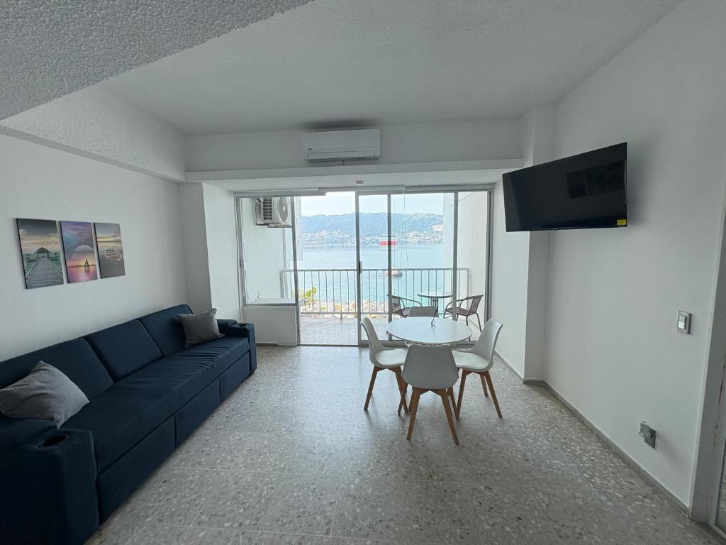 a living room with a blue couch and a table at Loft con vista al mar, playa, wifi, súper ubicado in Acapulco