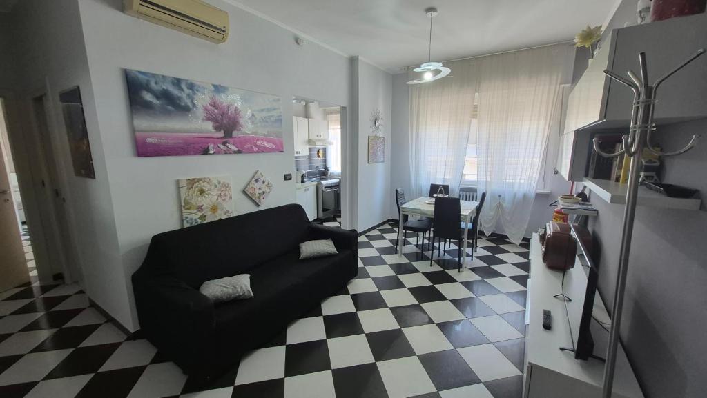 a living room with a black couch and a checkered floor at Appartamento Saretta in Asti