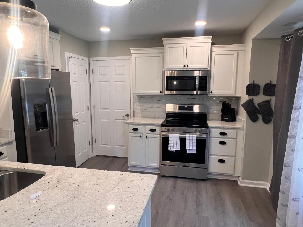 a kitchen with white cabinets and a stove top oven at Greystone Ranch Pet Friendly in Clarksville