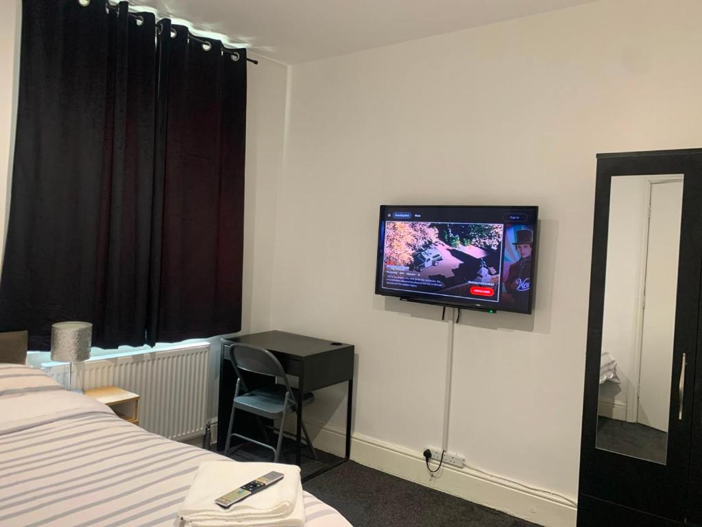 a hotel room with a tv on the wall at Haven House in Hull