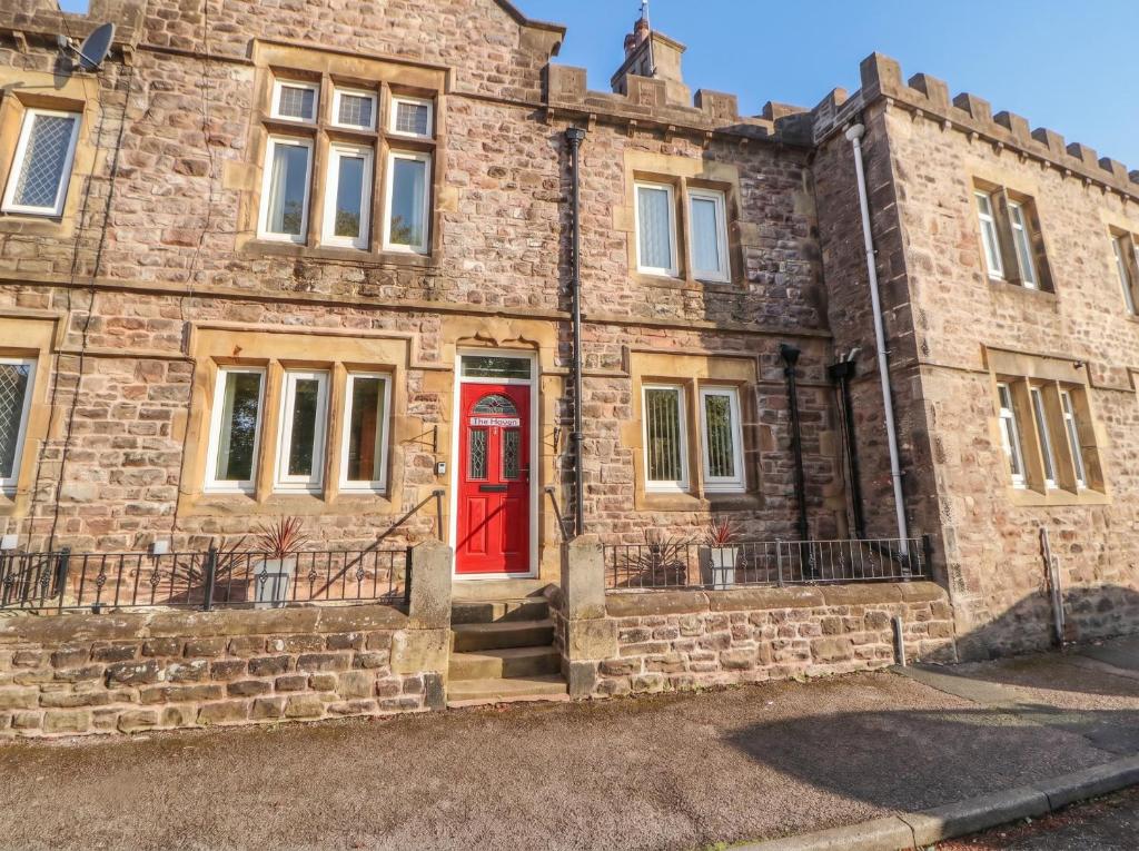 an old brick building with a red door at The Haven in Morecambe