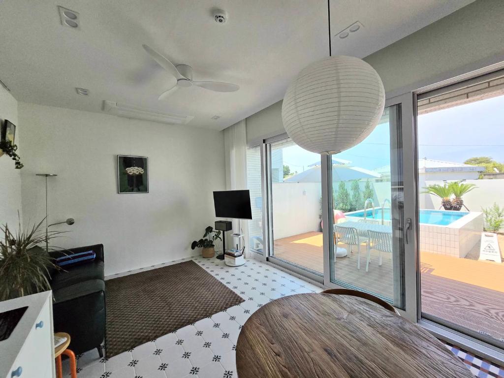 a living room with a table and a view of a pool at 유유히 in Sowang-dong