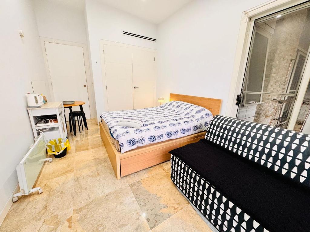a bedroom with two beds and a table and a window at Relax and Retreat Studio Flat in Glenwood