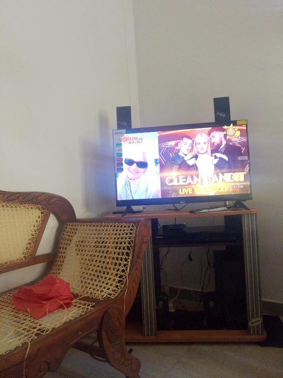 a flat screen tv sitting on a table with two chairs at GD Guest in Bentota