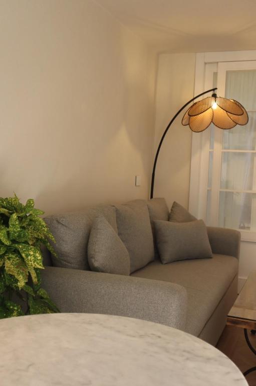 a living room with a couch and a lamp at A Lómbre in Ḩarīq al Kufūr