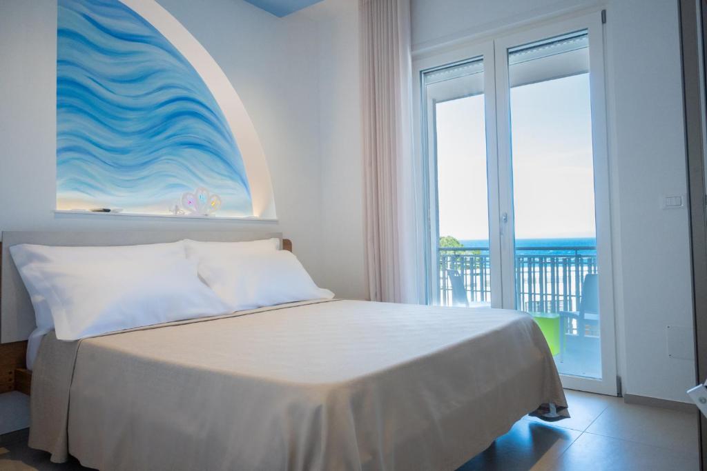 a bedroom with a bed with a view of the ocean at Lumina Rooms in Torre dell'Orso
