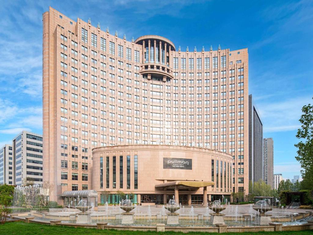 a large building with a clock on top of it at Pullman Beijing South - Newly Renovated in Beijing
