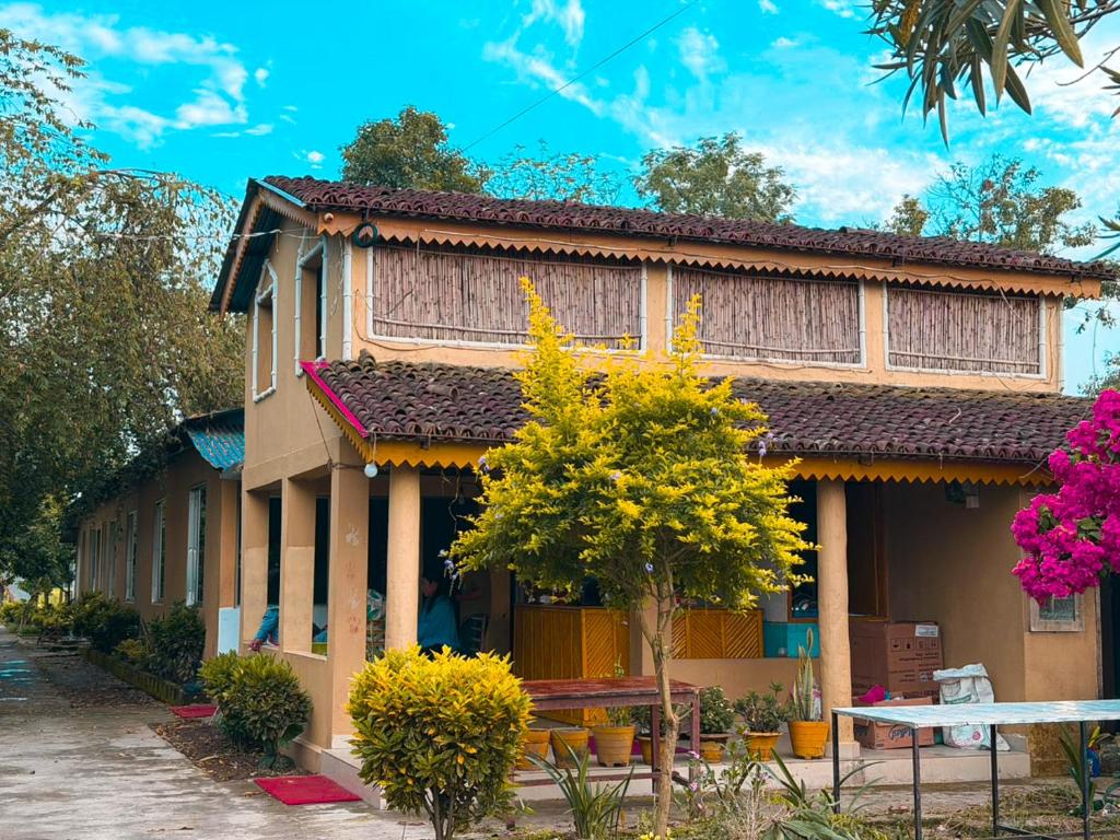 a building with a tree in front of it at Tamu Homestay in Jhawāni