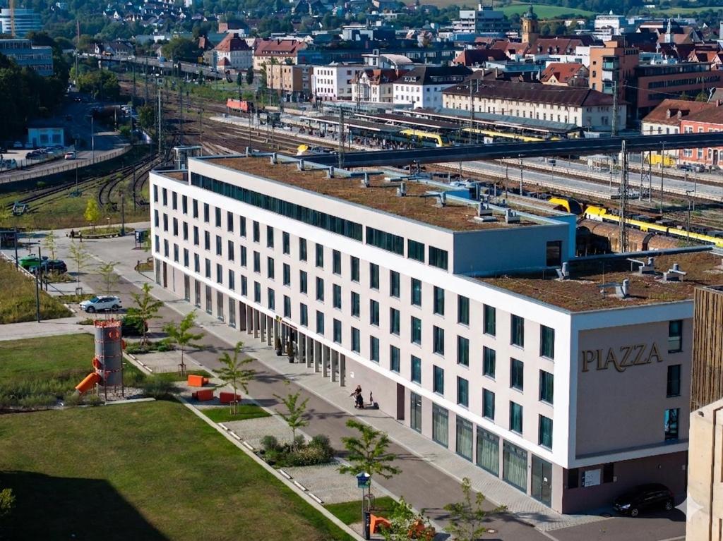 an overhead view of a white building next to a train at Piazza Hotel und Restaurant in Aalen