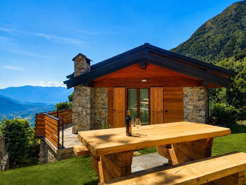 a picnic table in front of a cabin with mountains at SkyWood Chalet, Panoramic Mountain and Lake Views in Mello