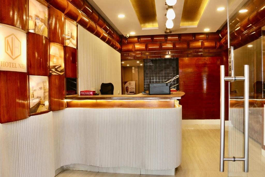 a restaurant with a white counter in a room at HOTEL Nh MAJESTIC in Bangalore