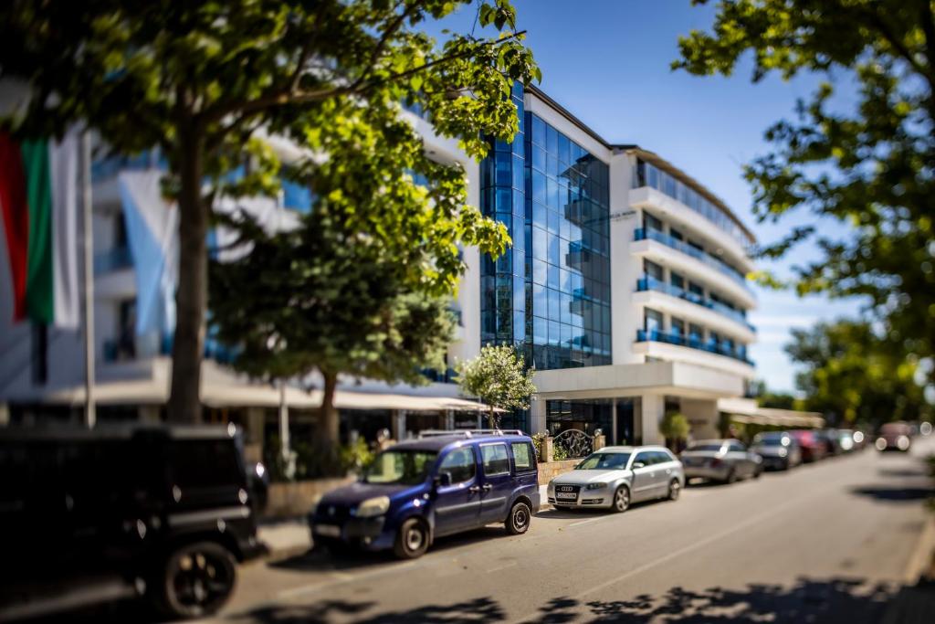 a street with cars parked in front of a building at ELIA MARe Hotel ALL Inclusive - Free Beach Access in Kiten
