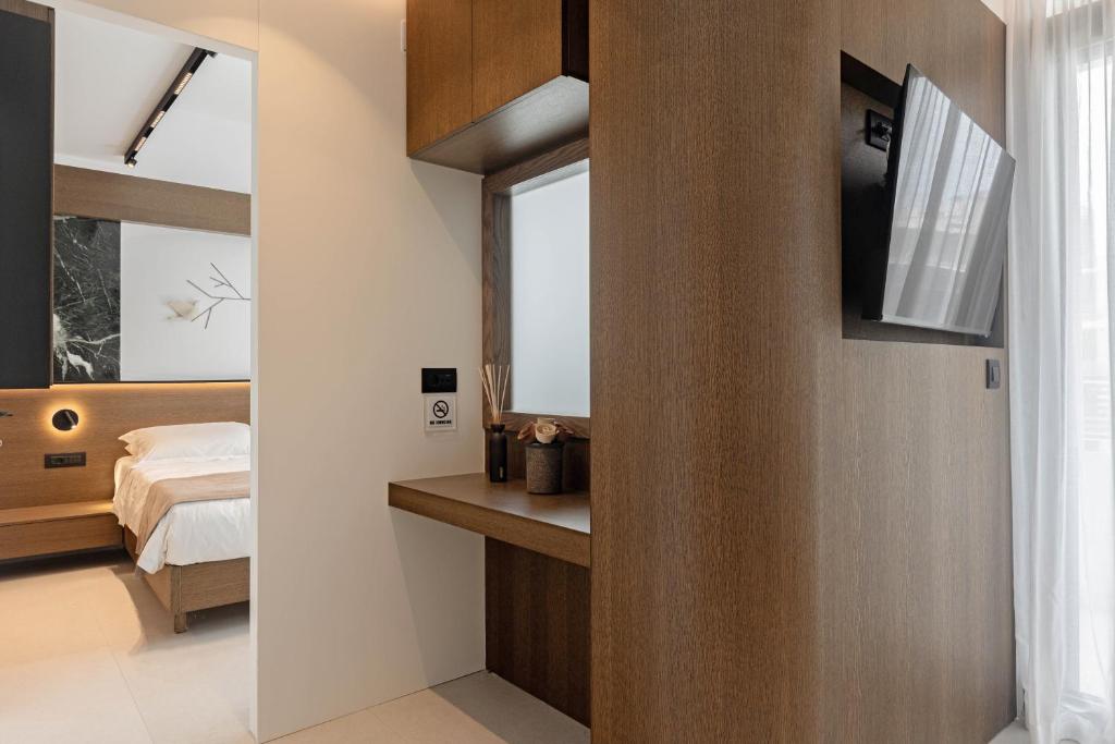 a bedroom with a bed and a window and a mirror at IzaVera Luxury Suites - Vera in Heraklio