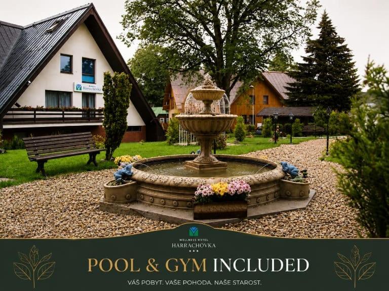a fountain in a yard in front of a house at Wellness hotel Harrachovka in Harrachov