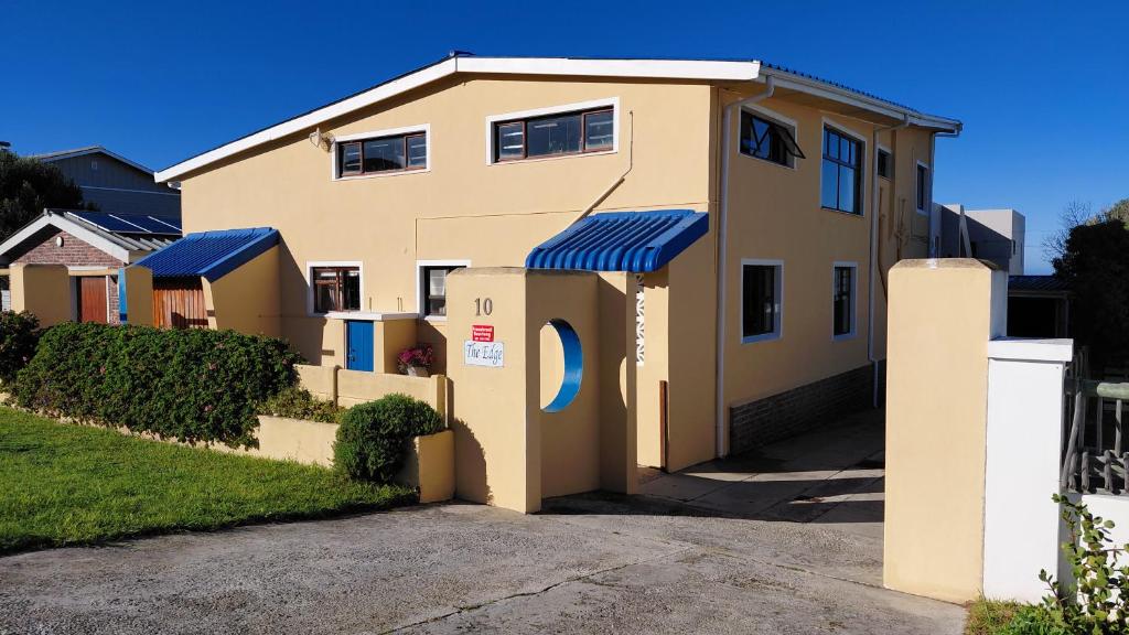 a house with blue awnings on the side of it at The Edge in Franskraalstrand