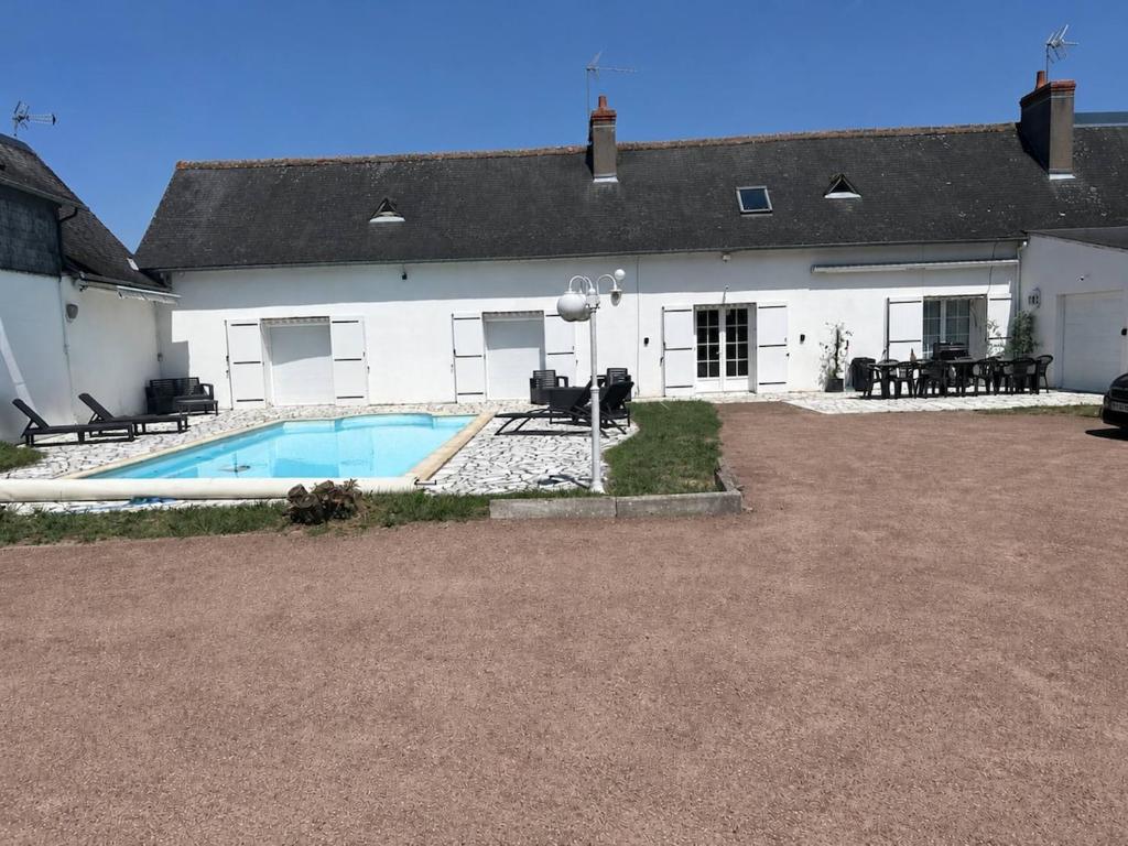 a house with a swimming pool in front of it at Piscine chauffée partagée avec terrasse privative in Joué-lès-Tours