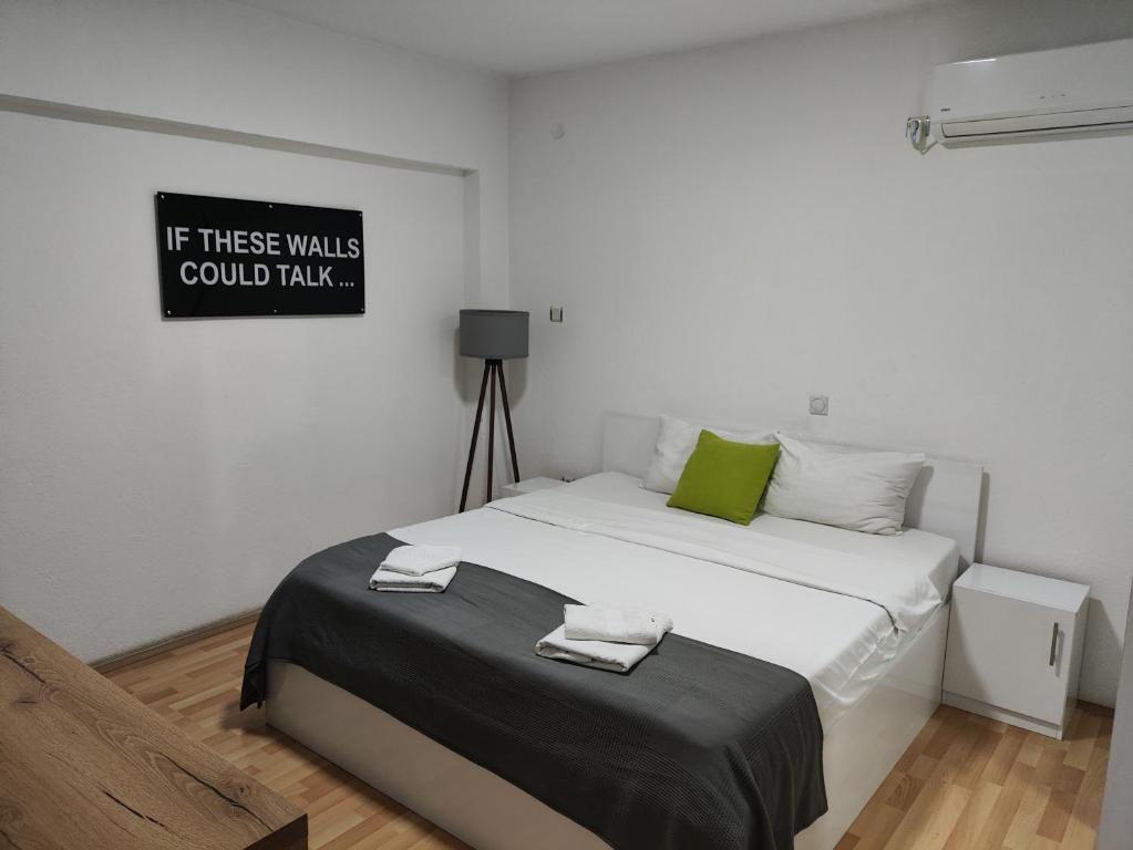 a bed in a room with a sign on the wall at Vila Vanila in Gevgelija
