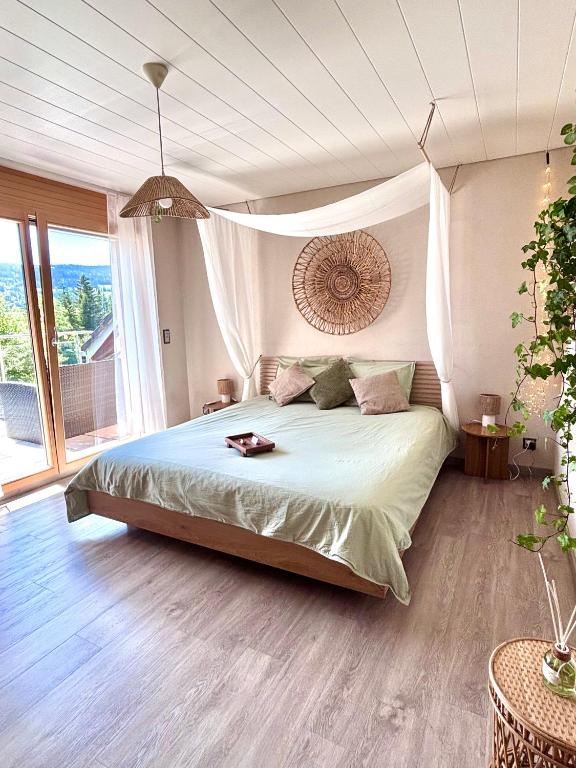 a bedroom with a large bed and a large window at Lake View Balcony in Le Chenit