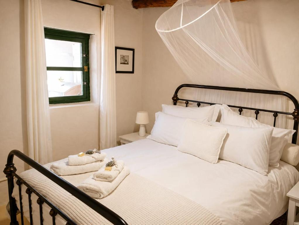 a bedroom with a white bed with towels on it at Old Corner Cottage in McGregor