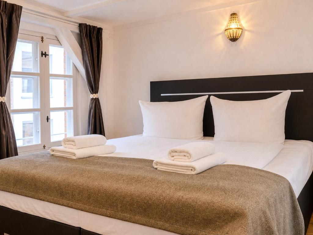 a bedroom with a large bed with towels on it at Wismar Apartments - Cozy and Central in Wismar