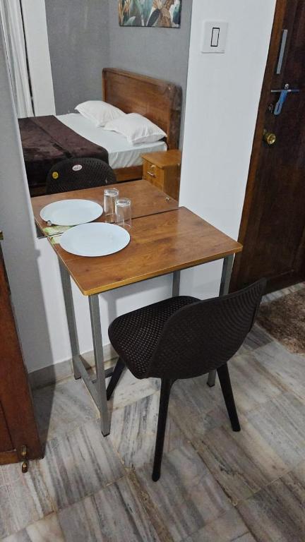 a wooden table with a chair and a bed at Easystayhomestay in Kunnamangalam