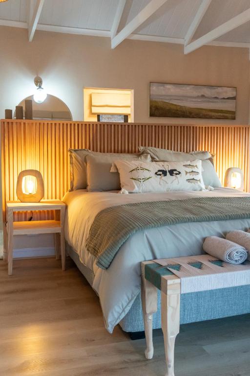 a bedroom with a large bed with a wooden headboard at Nicara Luxury Ecocabin Honeypunch in Keysers