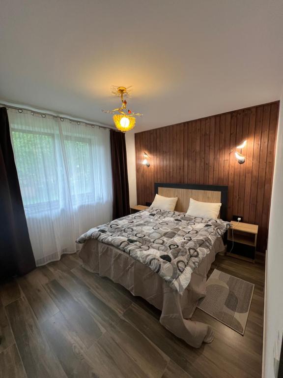a bedroom with a bed and a chandelier at Котедж GLORIA будинок повністю in Yaremche